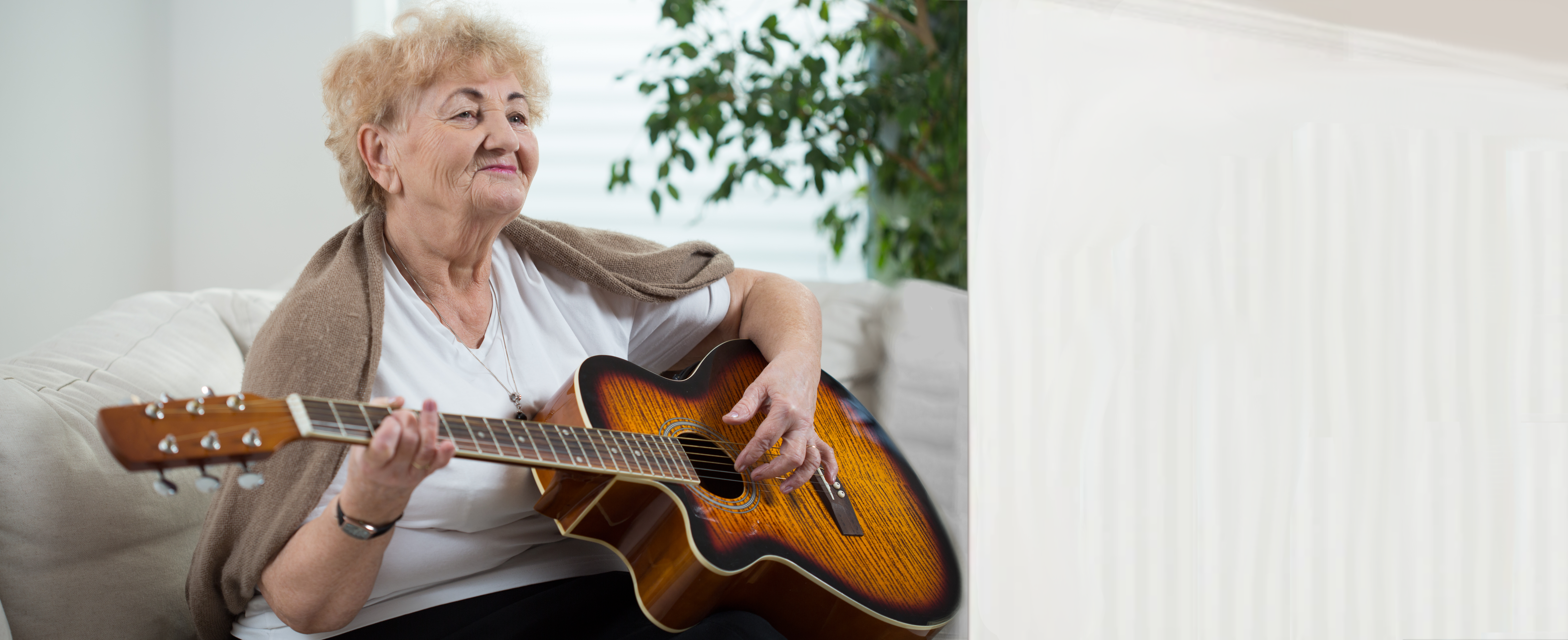 elderly woman playing guitar